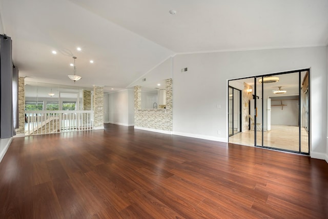 unfurnished living room featuring hardwood / wood-style floors and lofted ceiling