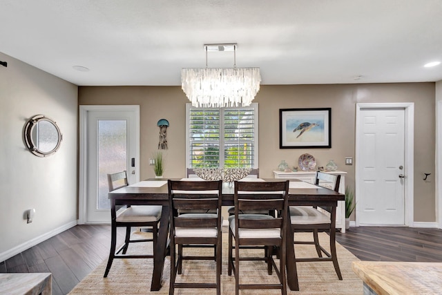 dining room with dark hardwood / wood-style floors and a notable chandelier