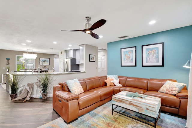 living room with ceiling fan and light wood-type flooring