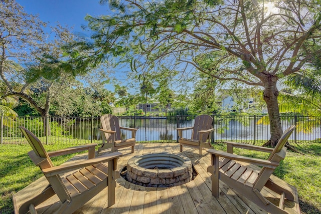 wooden terrace featuring a water view and an outdoor fire pit