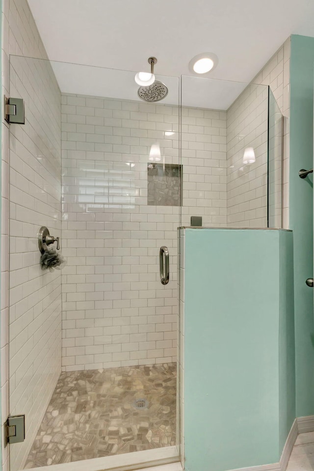 bathroom featuring a shower with shower door