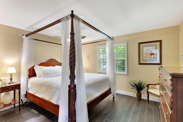 bedroom featuring a textured ceiling and dark wood-type flooring