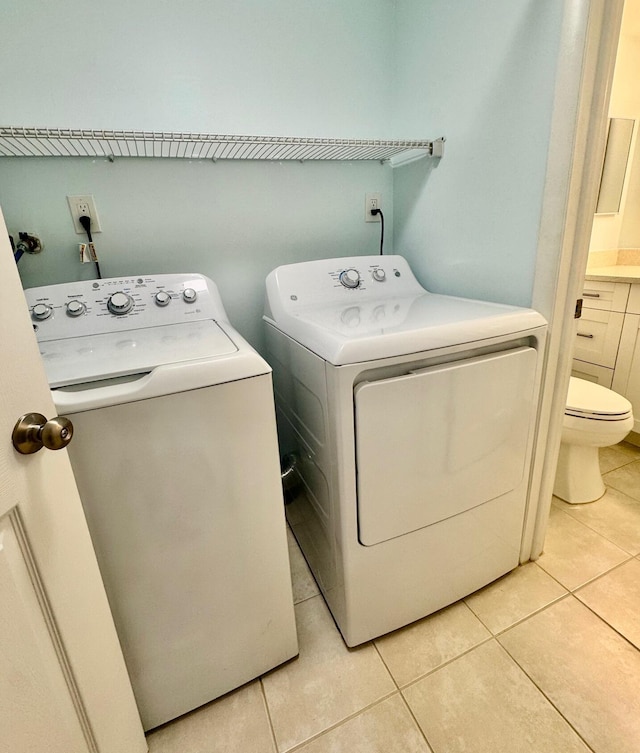 laundry area with light tile patterned floors and washer and dryer