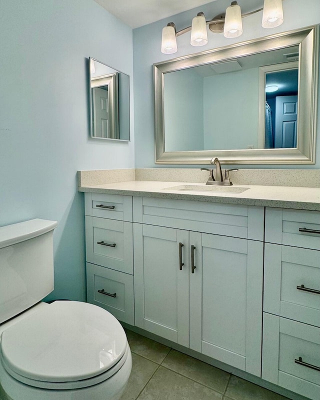 bathroom featuring tile patterned flooring, vanity, and toilet