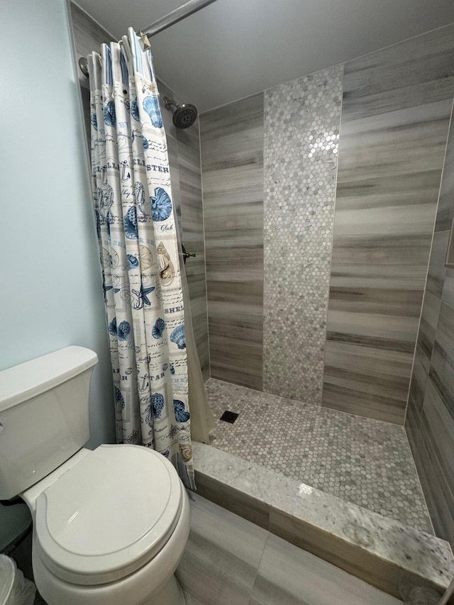 bathroom with toilet and a shower with shower curtain