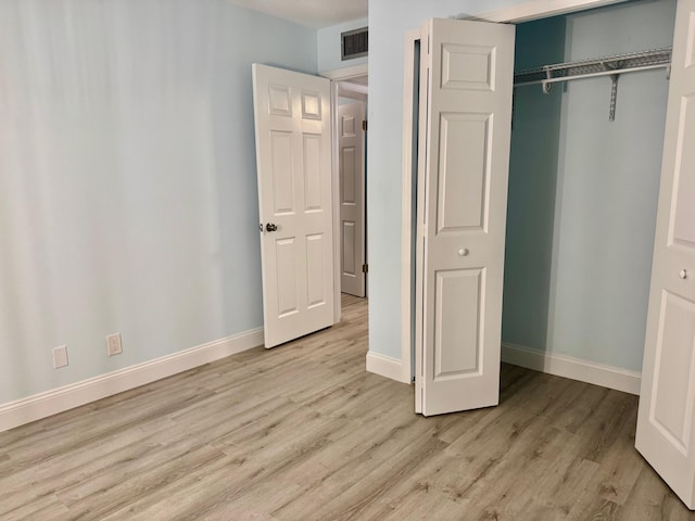 unfurnished bedroom with a closet and light hardwood / wood-style floors