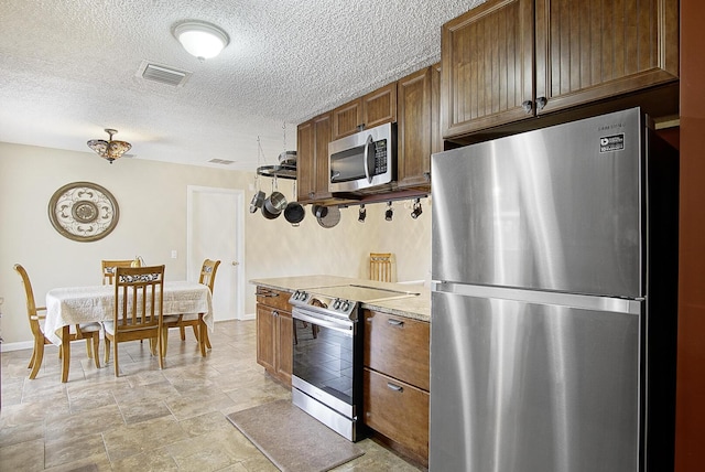 kitchen featuring a textured ceiling and appliances with stainless steel finishes