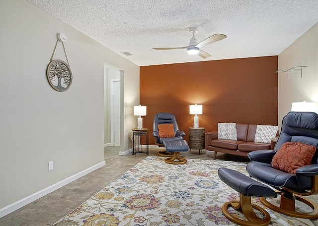 living room featuring a textured ceiling and ceiling fan