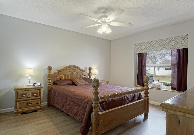 bedroom with ceiling fan, a textured ceiling, and light wood-type flooring