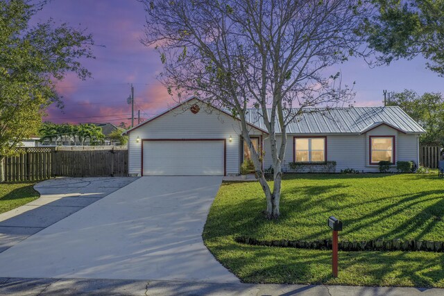 ranch-style house featuring a yard and a garage