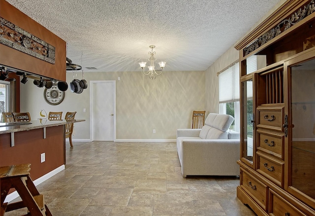 living area featuring a notable chandelier and a textured ceiling