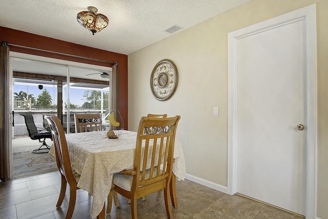 tiled dining space featuring a textured ceiling