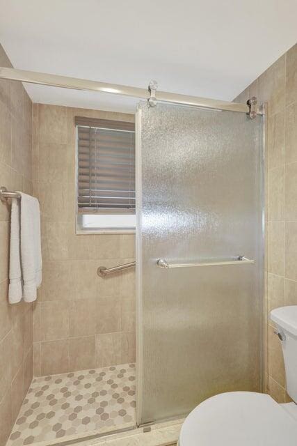 bathroom with toilet and walk in shower