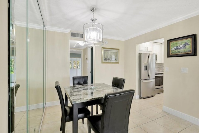 dining room featuring crown molding, light tile patterned floors, and an inviting chandelier