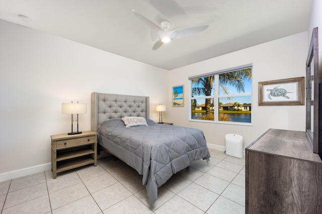 bedroom with a water view, ceiling fan, and light tile patterned flooring