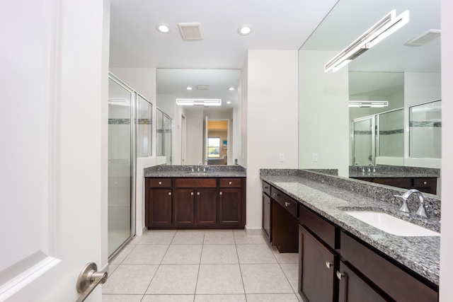 bathroom featuring tile patterned flooring, vanity, and a shower with door