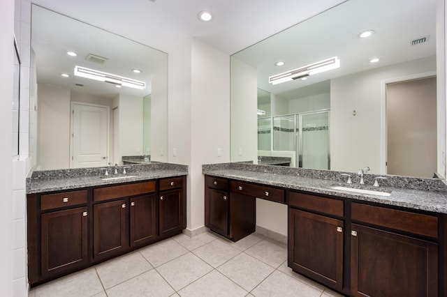 bathroom with tile patterned floors, vanity, and a shower with shower door