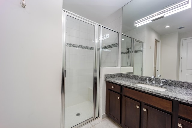 bathroom with tile patterned floors, vanity, and a shower with door