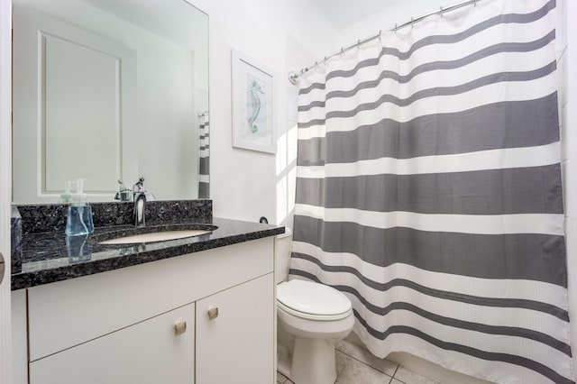 bathroom with toilet, vanity, and tile patterned floors