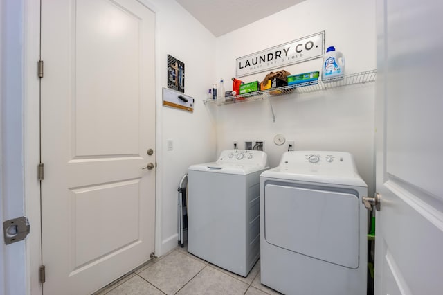 clothes washing area featuring washing machine and clothes dryer and light tile patterned floors