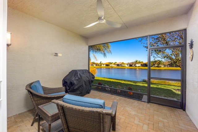 sunroom / solarium with a water view and ceiling fan