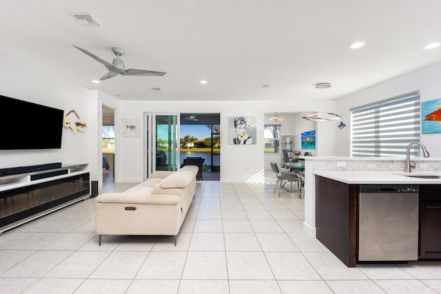 living room featuring ceiling fan, light tile patterned floors, and sink