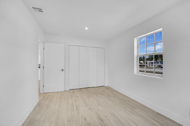 unfurnished bedroom featuring a closet and light hardwood / wood-style flooring