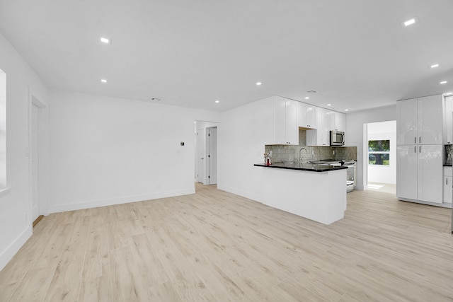 unfurnished living room featuring light hardwood / wood-style floors and sink