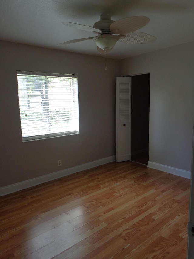 spare room with ceiling fan and light wood-type flooring