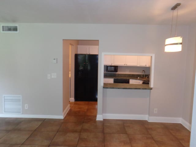 kitchen featuring white cabinetry, sink, dark tile patterned floors, decorative light fixtures, and black appliances