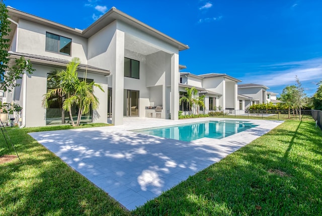 back of house with a fenced in pool, a patio area, and a yard