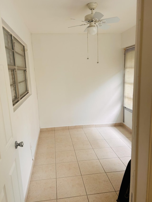 empty room featuring light tile patterned floors and ceiling fan