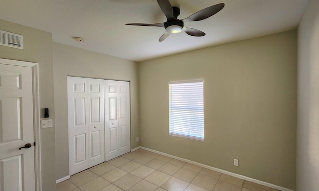 unfurnished bedroom with ceiling fan, a closet, and light tile patterned floors