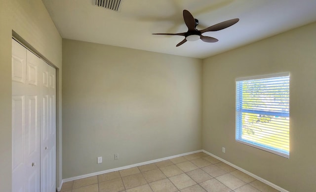 tiled empty room with ceiling fan