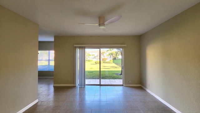 tiled empty room featuring ceiling fan