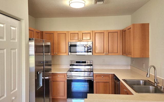 kitchen featuring sink, stainless steel appliances, and a textured ceiling