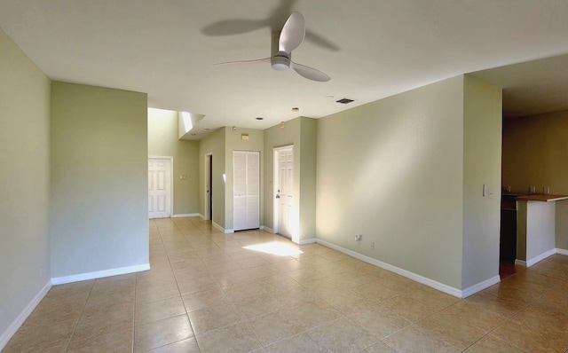 tiled empty room featuring ceiling fan