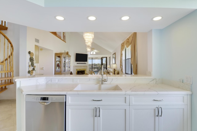 545 Bay Colony Dr N, Juno Beach, FL 33408 - kitchen with stainless steel dishwasher, a sink, open floor plan, white cabinetry, and light stone counters