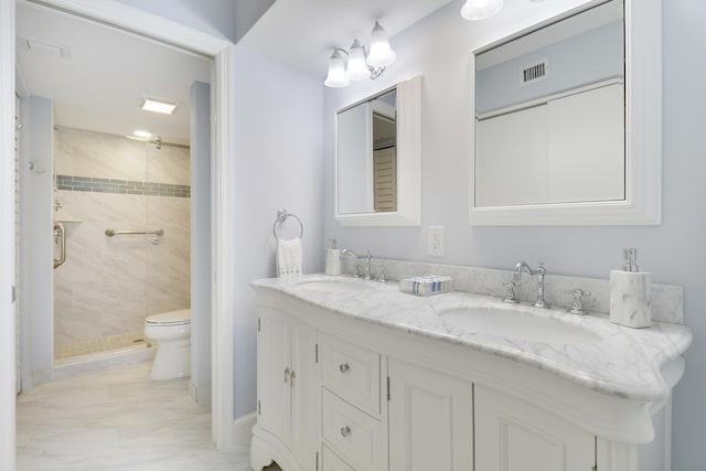 bathroom featuring vanity, a shower with shower door, and toilet