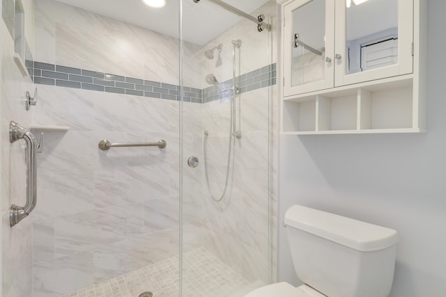 bathroom with toilet and a shower with shower door