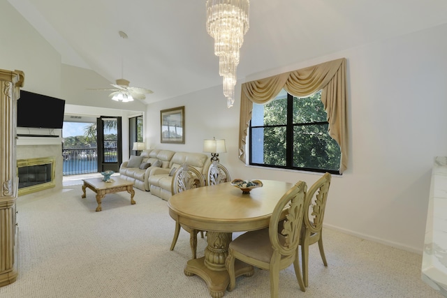 dining room featuring ceiling fan with notable chandelier, light colored carpet, and lofted ceiling