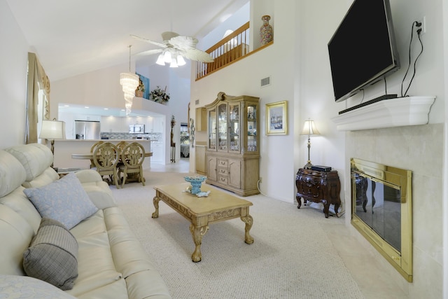 living room with light carpet, high vaulted ceiling, a tile fireplace, and ceiling fan