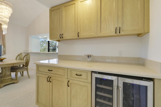 kitchen with light brown cabinets, light colored carpet, wine cooler, and vaulted ceiling