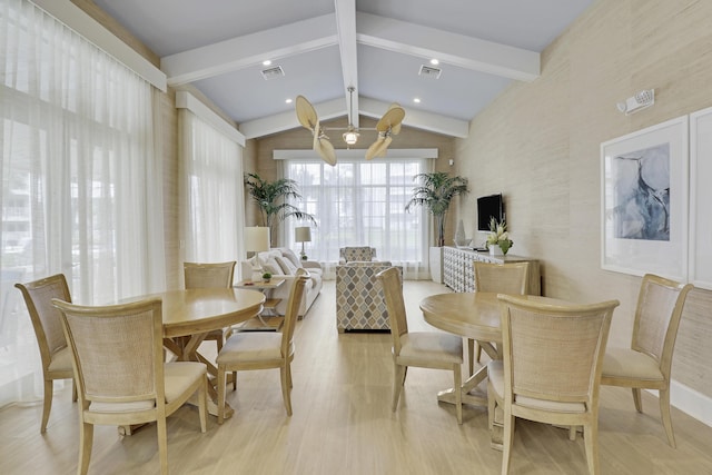 dining area with lofted ceiling with beams and light hardwood / wood-style flooring