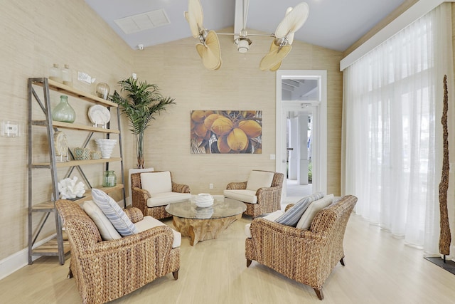 sitting room with a healthy amount of sunlight, light wood-type flooring, and lofted ceiling