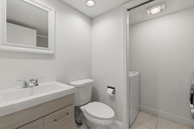 bathroom featuring washer / clothes dryer, tile patterned flooring, vanity, and toilet