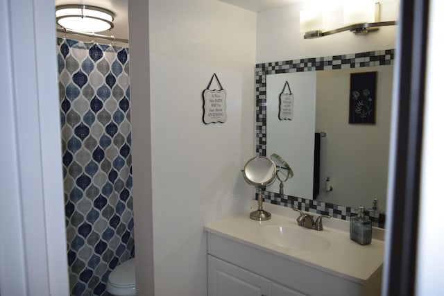 bathroom with a shower with shower curtain, vanity, and toilet