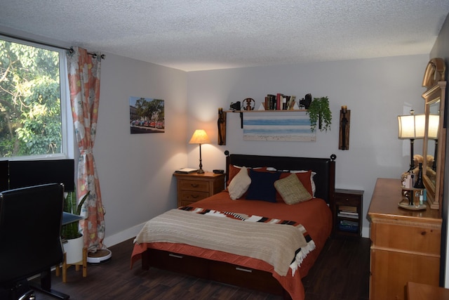 bedroom with dark hardwood / wood-style flooring and a textured ceiling