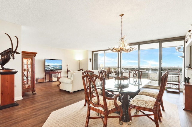 dining room featuring floor to ceiling windows, a chandelier, dark wood-type flooring, and a textured ceiling