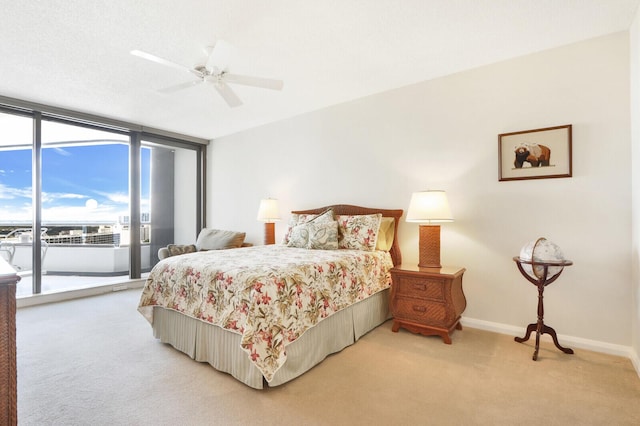 bedroom with floor to ceiling windows, access to exterior, ceiling fan, and light carpet